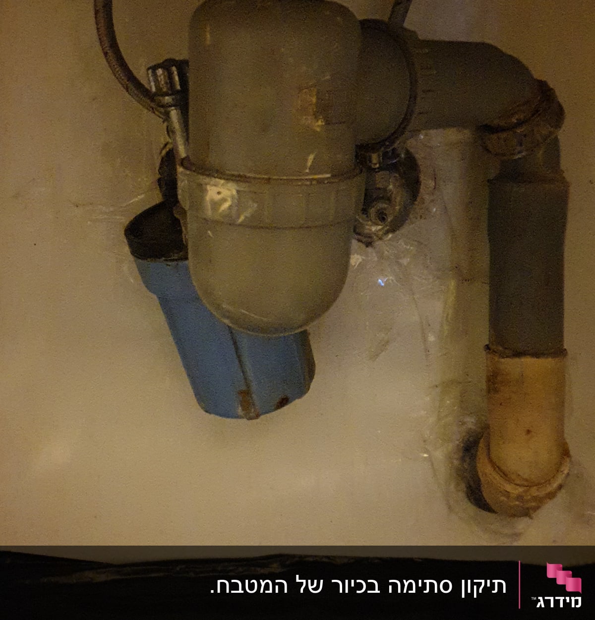 צנרת מתחת לכיור עם מסנן מים כחול